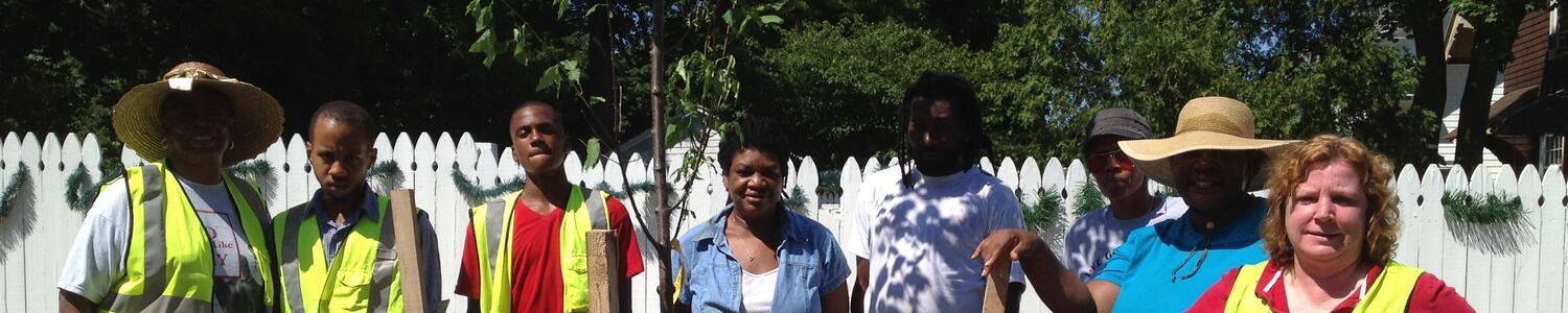 Group smiling while planting a tree