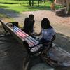Two volunteers spray painting bench