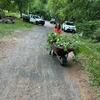 Eileen wheelbarrowing pulled weeds from memorial garden to riverbank!