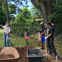 Jasmine showing the kids how to shovel the mulch!