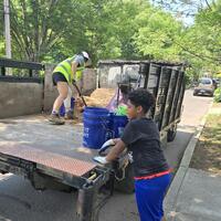 Yvonne shoveling mulch into buckets for the kids!