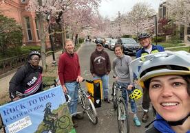 cyclists on ride under cherry blossoms