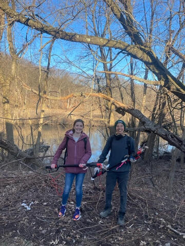 de-vining volunteer with URI staff behind Wilbur Cross School